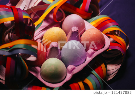Painted colorful Easter eggs nestled in a violet box flatly. LGBT gay vibrant colors garland. Festive wallpaper, greeting card Festive springtime pic. Painted colorful Easter eggs nestled in a violet box flatly. LGBT gay vibrant colors garland. Festive wallpaper, greeting card Festive springtime pic. 121457883