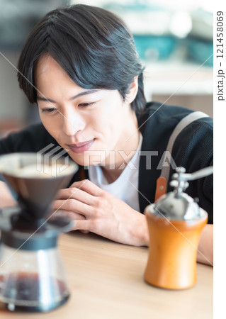 コーヒーのドリップ時間を楽しむ男性バリスタのポートレート 121458069