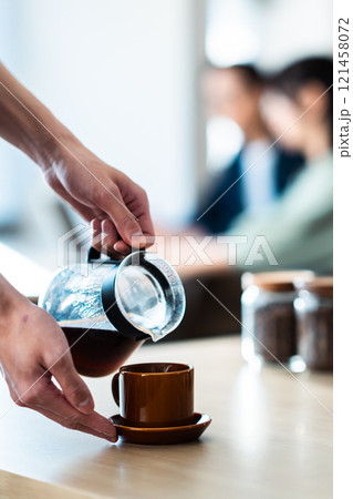 落ち着いたカフェとコーヒーを淹れる手元　顔無し 121458072