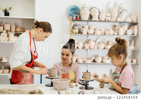 Artists crafting pottery in a creative studio during a sunny afternoon 121458154