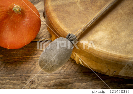 handmade, native American style, shaman frame drum covered by goat skin with a beater or a rustic wood with winter squash 121458355