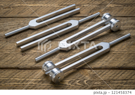 Set of weighted and unweighted metal tuning forks used for tuning musical instruments, sound therapy, chakra healing or relaxation. 121458374