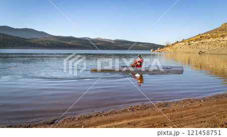 Senior male rower in a coastal rowing shell - Carter Lake in fall or winter scenery in northern Colorado. Senior male rower in a coastal rowing shell - Carter Lake in fall or winter scenery in northern Colorado. 121458751