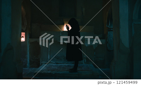 Silhouette Of The Dark Monk Praying In The Night Church  121459499