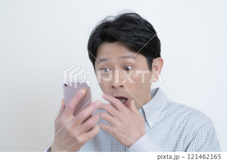 スマホの画面を見て驚くミドル男性 スマホの画面を見て驚くミドル男性 121462165