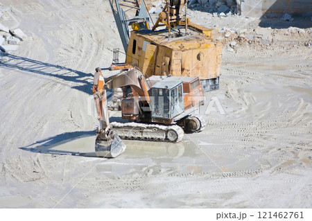 Orange crawler excavator in a marble quarry 121462761