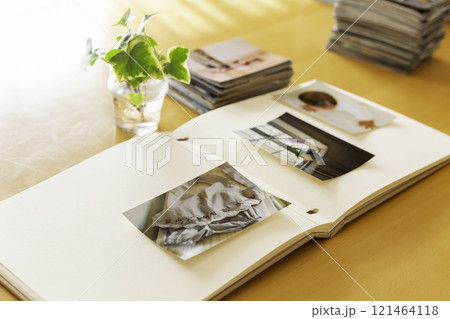 テーブルの上のアルバムと積み重ねた写真プリント 121464118