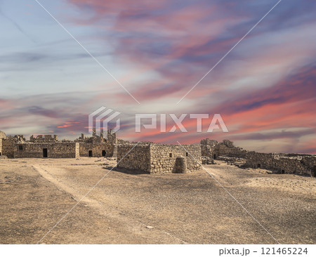 Ruins of Azraq Castle (Qasr al-Azraq) is a crusader castle (300AD),  central-eastern Jordan, 100 km east of Amman, Jordan. Against the background of a beautiful sky with clouds 121465224