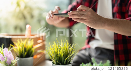 Modern Gardener Documenting Plant Growth with Smartphone Camera Modern Gardener Documenting Plant Growth with Smartphone Camera 121465836