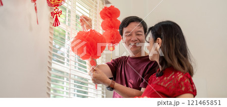 Elderly couple celebrating chinese new year home festive decoration indoor joyful atmosphere Elderly couple celebrating chinese new year home festive decoration indoor joyful atmosphere 121465851