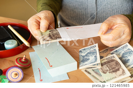 お年玉を準備する高齢者　孫のお年玉を用意するおばあちゃん　年金からお年玉を捻出 121465985