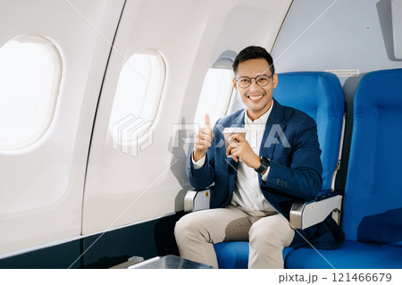 Asian executive excels in first class, multitasking with digital tablet, laptop and smartphone. Travel in style Asian executive excels in first class, multitasking with digital tablet, laptop and smartphone. Travel in style 121466679