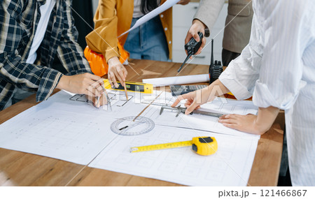 Creative architect projecting on the big drawings with architectural project at construction site Creative architect projecting on the big drawings with architectural project at construction site 121466867