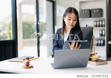 Asian woman lawyer working and gavel, tablet, laptop in front, Advice justice and law concept. 121467151