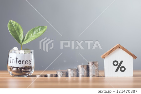 Stacks of coins arranged in ascending order with a small house model placed on a table, Home loan interest, mortgage refinancing, saving for housing, Planning for homeownership and stability 121470887