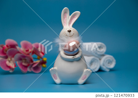 Easter white bunny with brown egg blue background and white towels. Easter 121470933