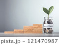 Glass jar filled with coins and a sprout labeled "Investment," placed beside stacked wooden blocks arranged like stairs with interest symbols, symbolizes financial growth, incremental savings Glass jar filled with coins and a sprout labeled "Investment," placed beside stacked wooden blocks arranged like stairs with interest symbols, symbolizes financial growth, incremental savings 121470987