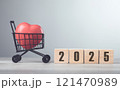 Wooden block with "2025" and a red heart placed in a shopping cart sit on a table, symbolizing future goals and investments in well-being, against a bright grey background Wooden block with "2025" and a red heart placed in a shopping cart sit on a table, symbolizing future goals and investments in well-being, against a bright grey background 121470989