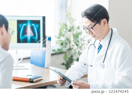 レントゲンを見せながら問診をするミドルの男性医師 121474245