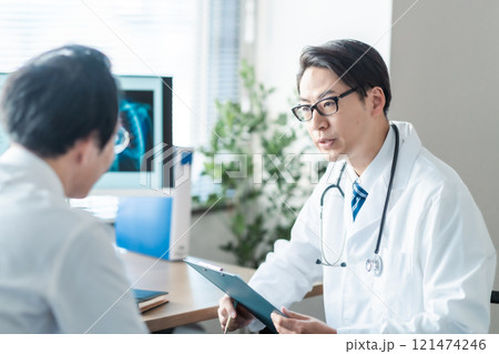レントゲンを見せながら問診をするミドルの男性医師 レントゲンを見せながら問診をするミドルの男性医師 121474246