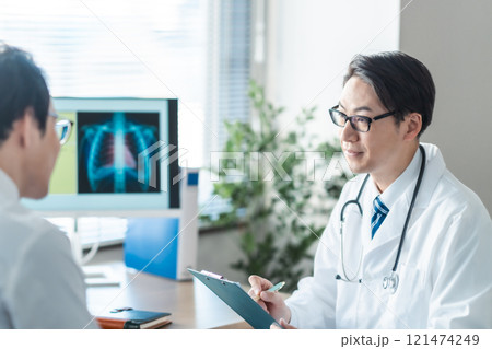 レントゲンを見せながら問診をするミドルの男性医師 レントゲンを見せながら問診をするミドルの男性医師 121474249