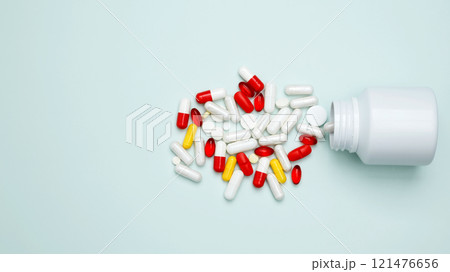 Concept of medicine, healthcare, pharmaceutical industry. Bottles with pills and capsules scattered Concept of medicine, healthcare, pharmaceutical industry. Bottles with pills and capsules scattered 121476656