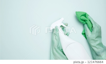 House cleaning. Womans hand in rubber glove holds cloths and cleaning product House cleaning. Womans hand in rubber glove holds cloths and cleaning product 121476664
