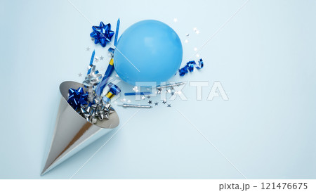 Concept of festive birthday celebrations. Party hat for birthday with colorful balloons, party hats, candles, confetti 121476675
