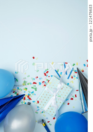Concept of festive birthday celebrations. Birthday attributes colorful balloons, party hats, candles, confetti 121476683