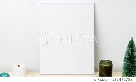 Christmas tree and candles creating a festive decoration. White frame for mockup with small Christmas tree and candles creating a festive decoration. White frame for mockup with small 121476788