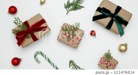 Natural holiday scene, wrapped Christmas gifts with green thuja branches creating a festive Natural holiday scene, wrapped Christmas gifts with green thuja branches creating a festive 121476814