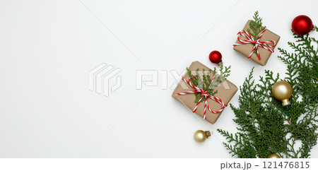 Festive, natural holiday scene, wrapped Christmas gifts with green thuja branches Festive, natural holiday scene, wrapped Christmas gifts with green thuja branches 121476815