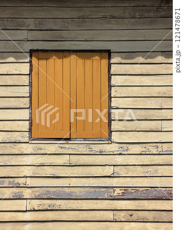 dusty yellow ancient wooden building facade with beautiful brown wooden windows. dusty yellow ancient wooden building facade with beautiful brown wooden windows. 121478671