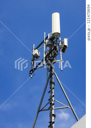 Wireless Communication Antenna pole, Mobile phone mast antenna pole on top of dilapidated building 121478694