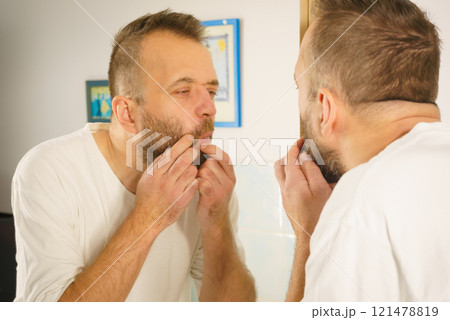 Man looking at pimples on his face 121478819