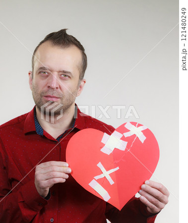 Sad adult man holding broken heart Sad adult man holding broken heart 121480249