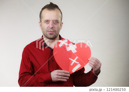 Sad adult man holding broken heart 121480250