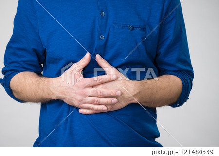 Man having crossed fingers on his stomach 121480339
