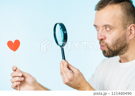 Uncertain man looking at love heart 121480490