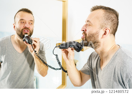 Man shaving trimming his beard 121480572