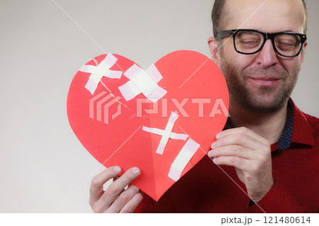Man holding broken heart Man holding broken heart 121480614