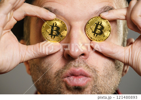 Man having bitcoin in eye 121480893