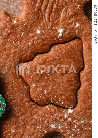 Christmas baking. Cutting out cookies from the textured dough. Festive xmas background. Top view, close up Christmas baking. Cutting out cookies from the textured dough. Festive xmas background. Top view, close up 121480979