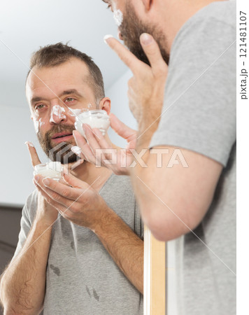 Man applying moisturizer cream in bathroom Man applying moisturizer cream in bathroom 121481107