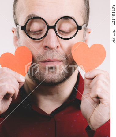 Sad man holding two red hearts. 121481108