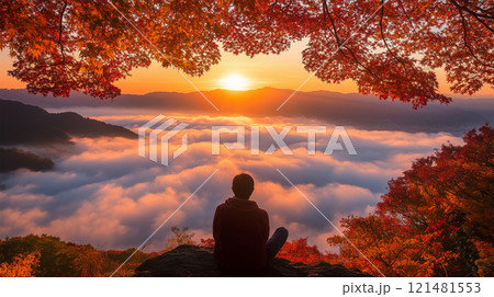 紅葉の山頂で静けさを楽しむ男性と朝日 121481553