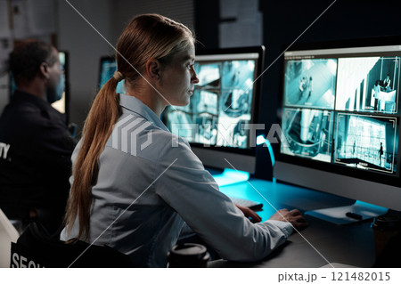 Woman observing cctv video camera Woman observing cctv video camera 121482015