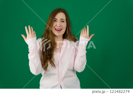 Photo of cheerful beautiful young woman standing isolated over white wall background. Looking camera showing winner gesture. Photo of cheerful beautiful young woman standing isolated over white wall background. Looking camera showing winner gesture. 121482274