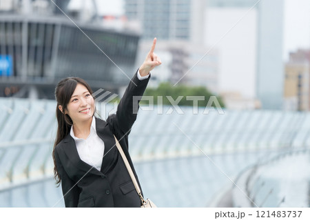 都会で指差しをするビジネスウーマン 都会で指差しをするビジネスウーマン 121483737