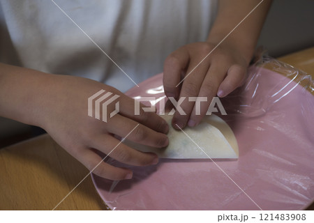 家庭で餃子を作る子供の手元 121483908